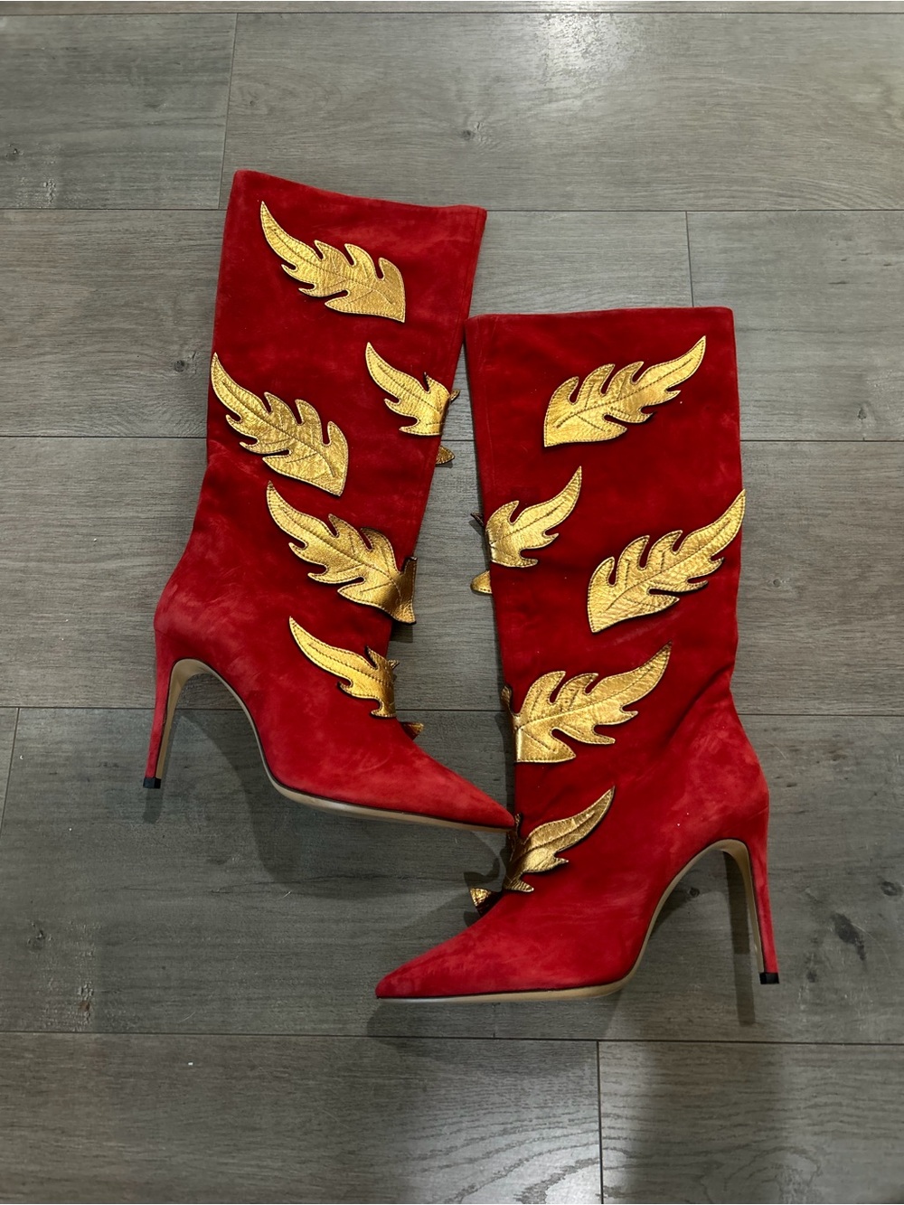 Lena Erziak
Size: EU 39
Red Suede Knee-High Heeled Boots with Gold Appliqué